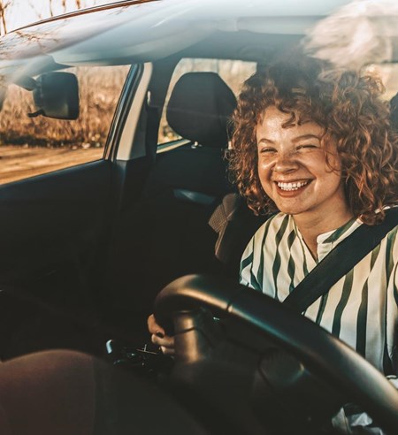 Young woman driving a car, smiling