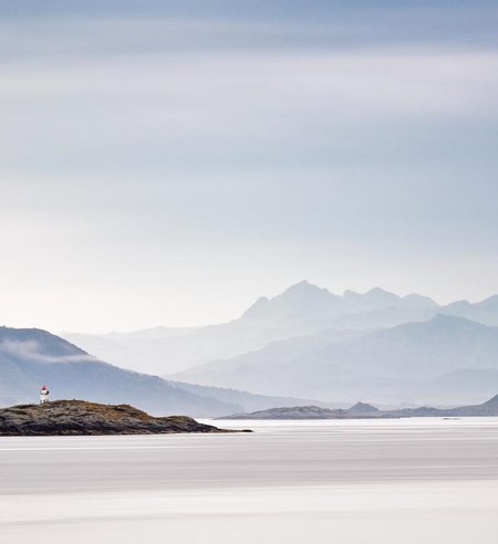 Coast of  Norway sea in clouds of haze. Beacon on a rock. Cloudy Nordic day on Lofoten islands